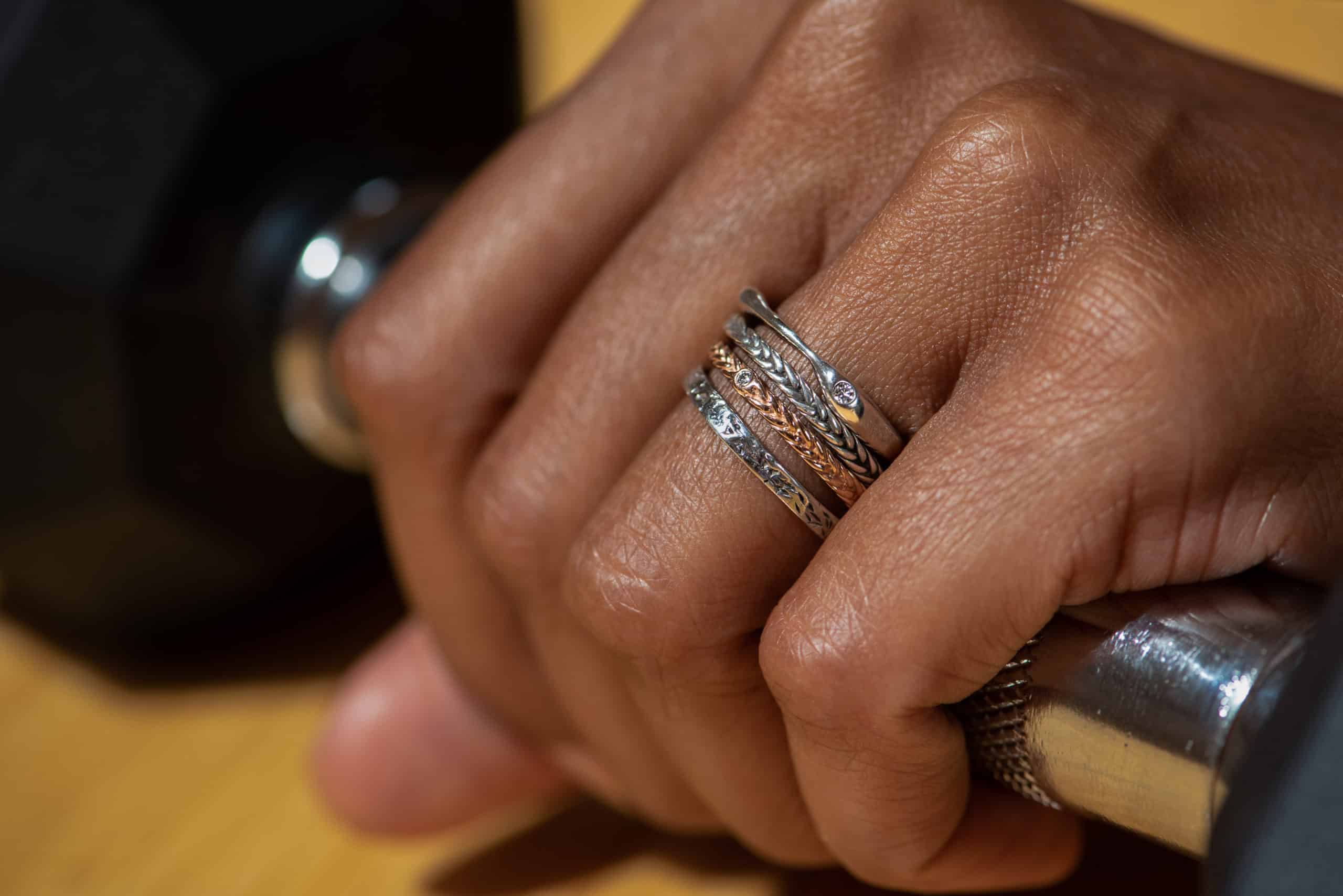 Close up of a hand wearing four thin bands