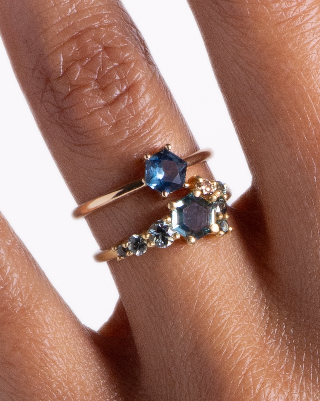 Kalmia Hex Blue Sapphire Ring and Radial Cluster Hex Blue Sapphire Ring on figure