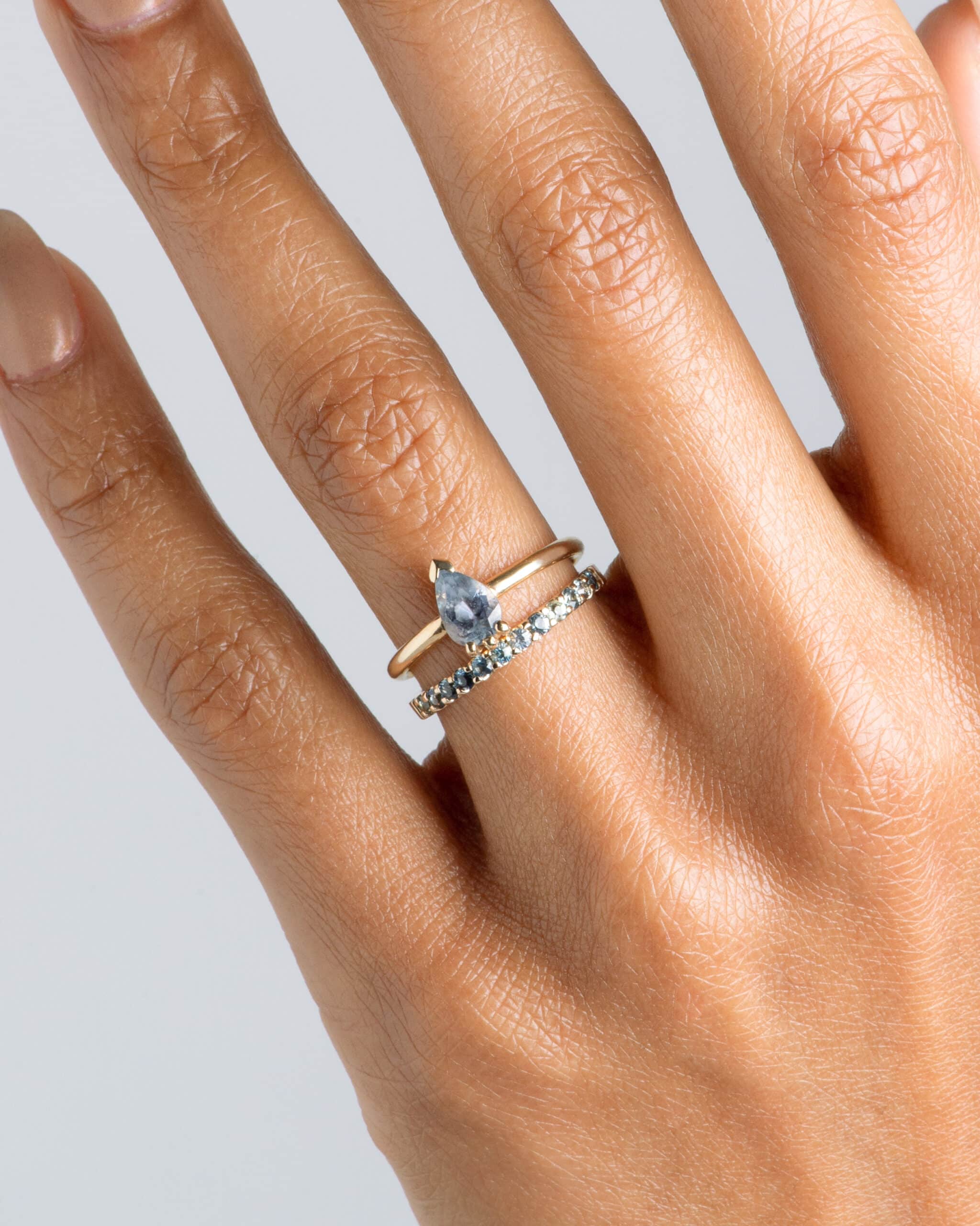 Lash Sky Blue Sapphire Pear Ring and Eternity Half Blue Green Sapphire Wide Band on figure
