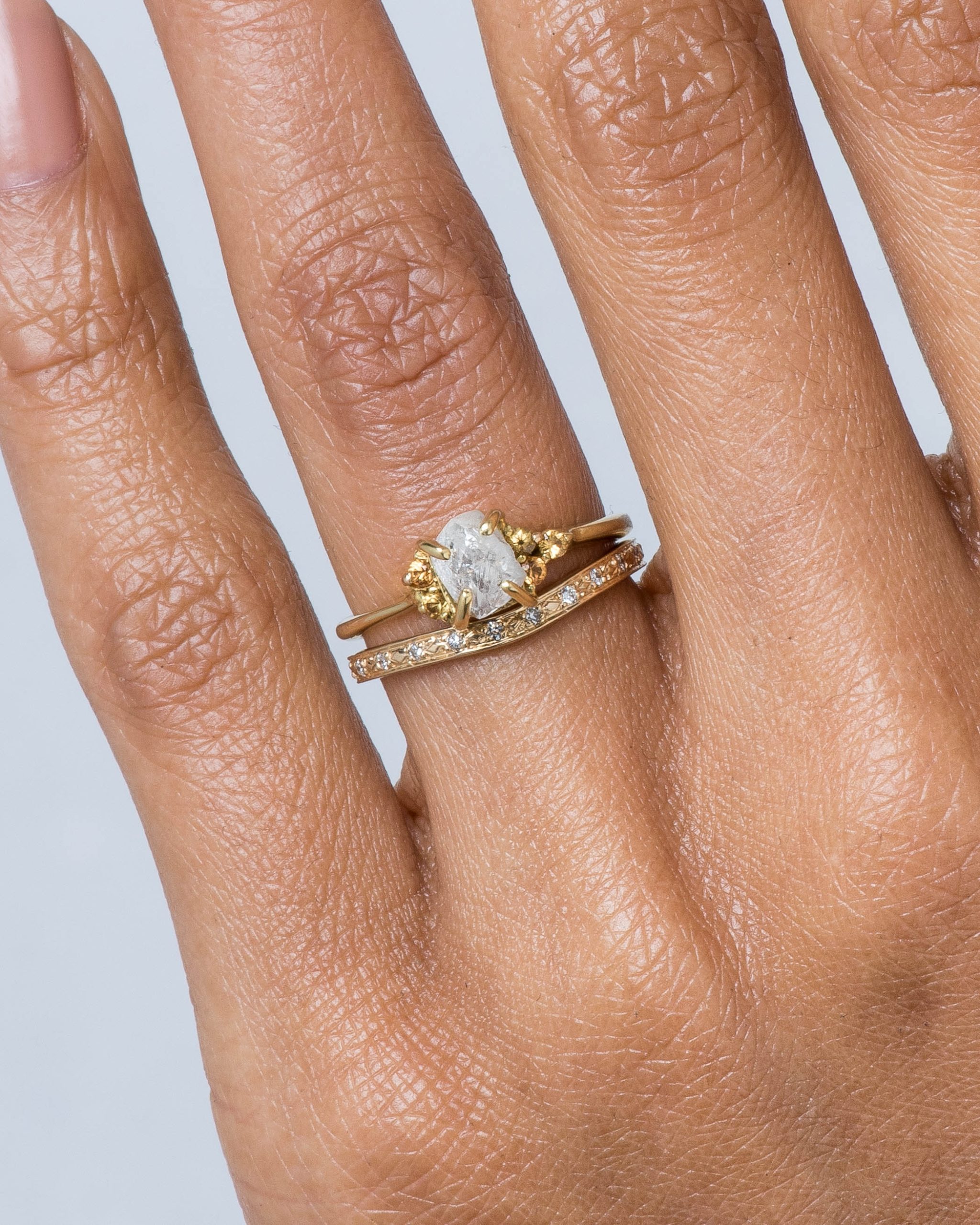 Luma Curved Diamond Band and Avens Asymmetrical Raw Diamond with Yellow Sapphire Ombré Ring on figure