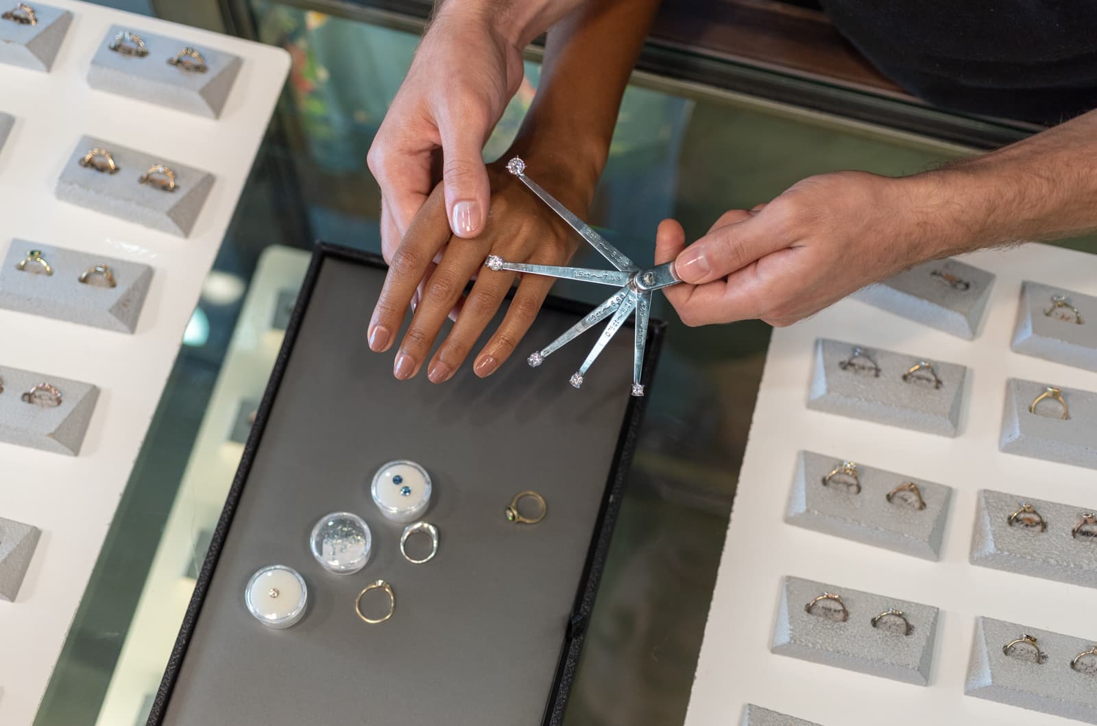 Photograph of two h ands trying different ring designs